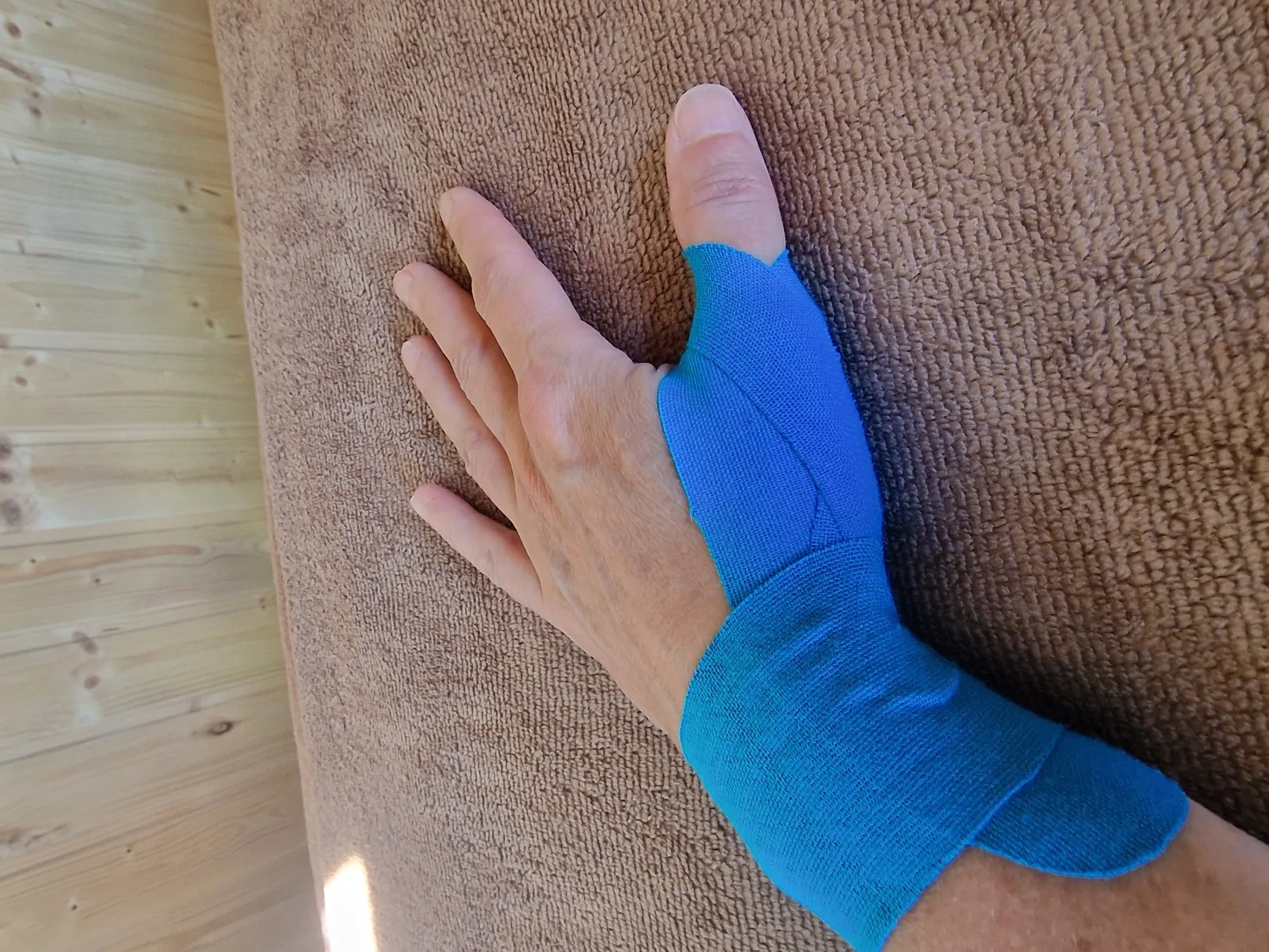 Medical taping aangebracht op hand en pols ter ondersteuning van de duim